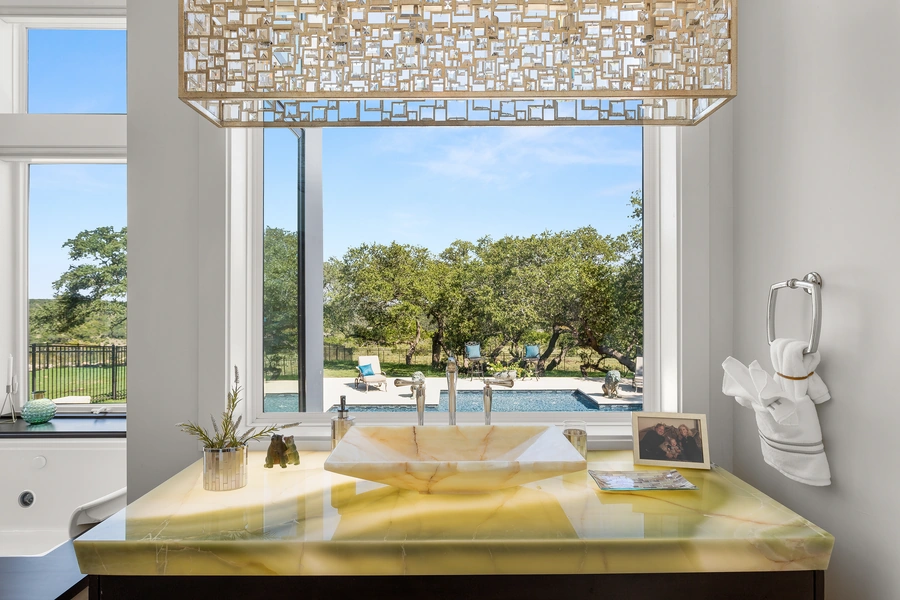 Stunning bathroom vanity at 1534 Circolare with backlit onyx countertop, vessel sinks, and warm ambient lighting