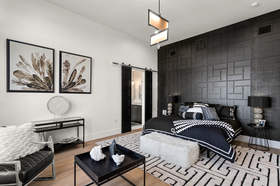 Sophisticated guest bedroom at 1534 Circolare with dramatic black accent wall, modern chandelier, and elegant neutral bedding