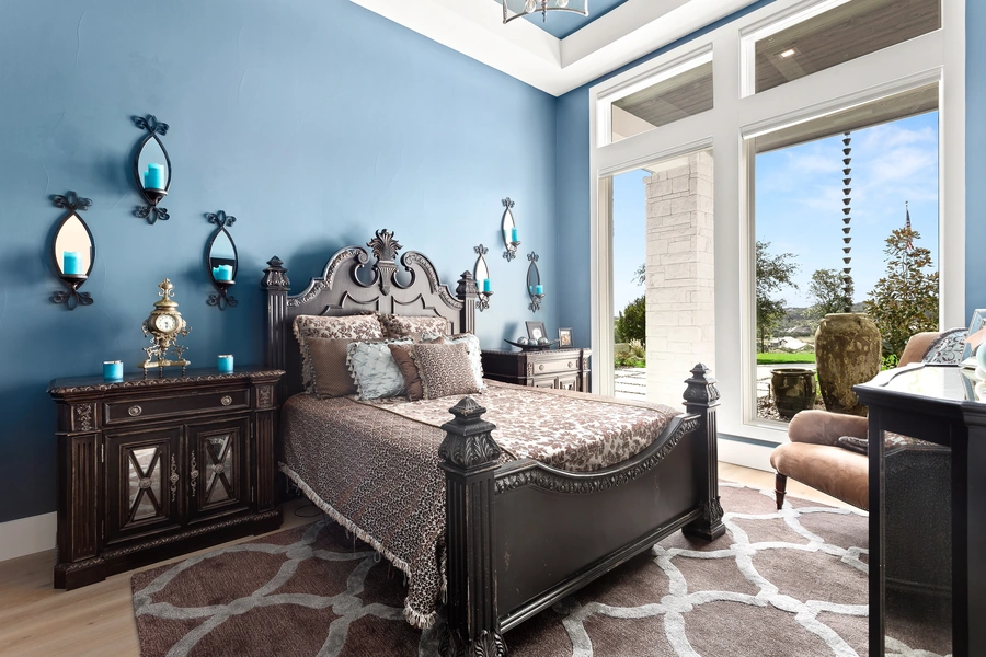 Inviting guest bedroom at 1534 Circolare with soft blue walls, upholstered headboard, and layered bedding in a serene palette