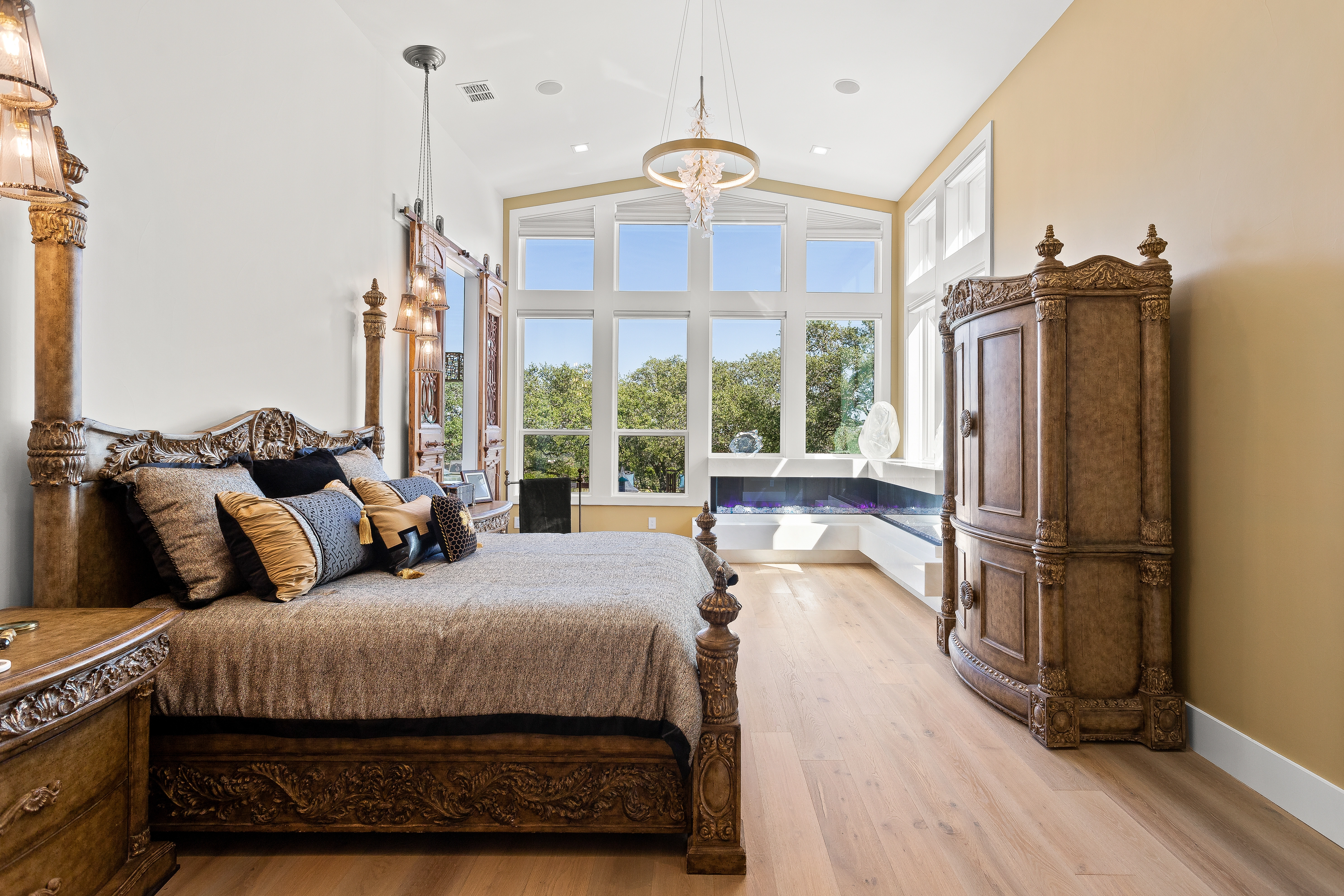Spacious master bedroom at 1534 Circolare featuring a coffered ceiling, neutral tones, plush seating area, and Hill Country views