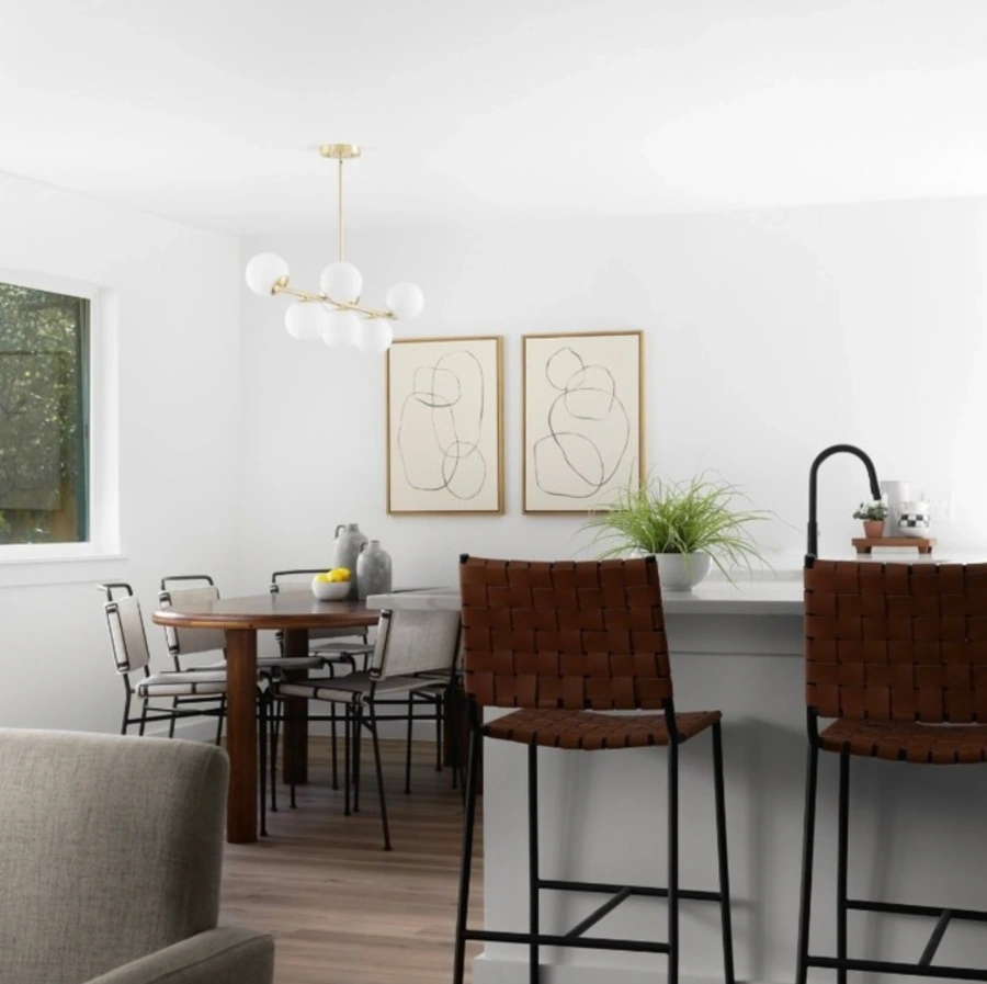 Contemporary dining room featuring modern lighting, leather bar stools, and minimalist wall art