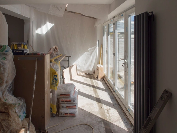 Room with floor to ceiling windows in the middle of a renovation
