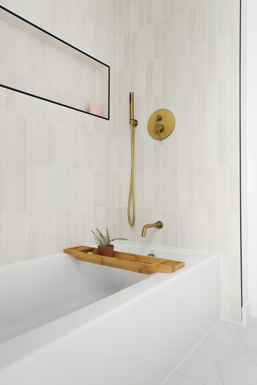 Modern shower with brass fixtures and white tile