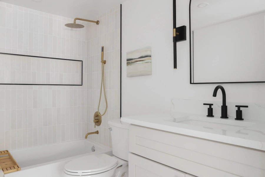 Modern white bathroom with black and brass fixtures