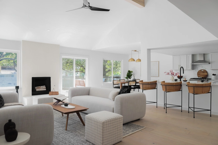 Modern open concept living room and kitchen with curved sofa and rattan barstools